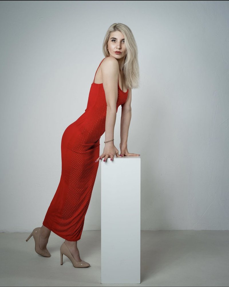 Dariia im roten Kleid an einem weißen Podest