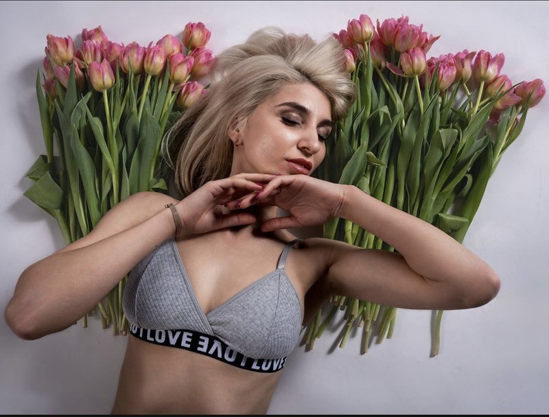 Dariia liegend zwischen rosa Tulpen