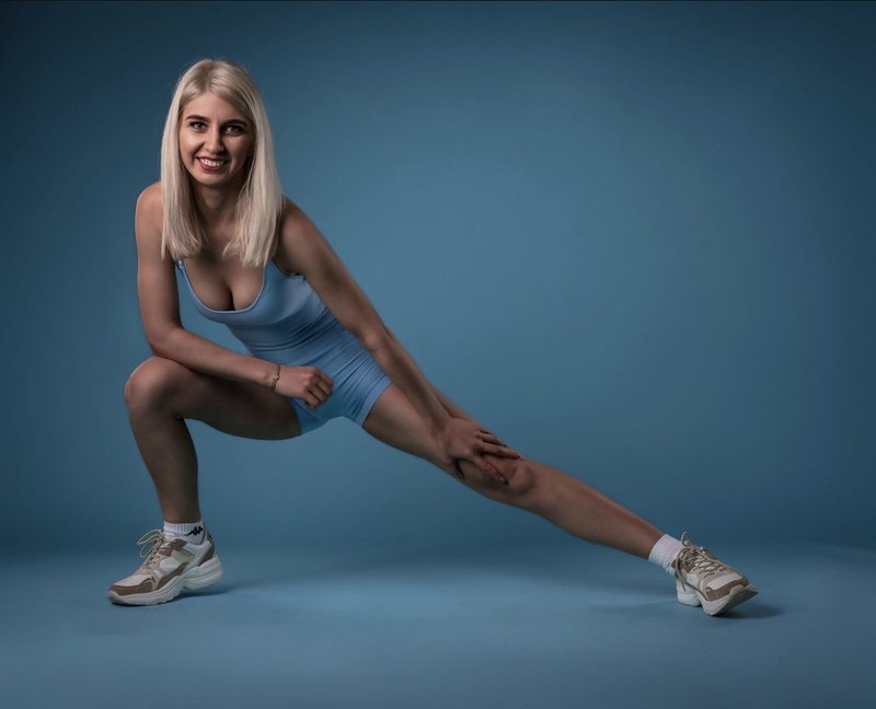 Dariia im blauen Sport-Outfit im Ausfallschritt
